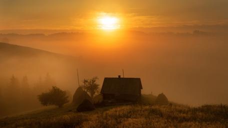 Serene Sunset Over a Rustic Cottage wallpaper