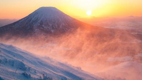 Frozen Sunrise over Foggy Mountain Peaks wallpaper
