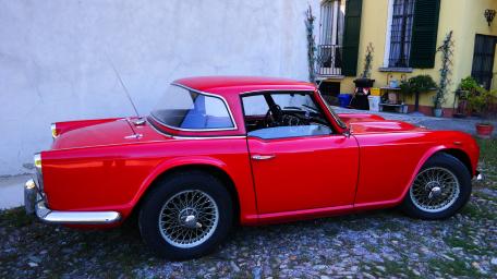 Classic Red Sports Car in Charmingly Rustic Setting wallpaper
