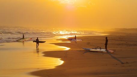 Surfing at Sunset on a Golden Beach wallpaper