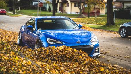 Majestic Blue Car Amid Autumn Leaves wallpaper