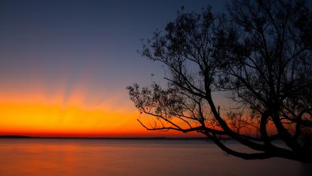 Burning Sunset Over Serene Lake Horizon wallpaper