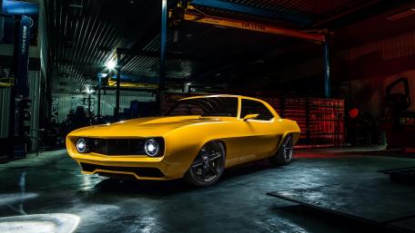 Vibrant Yellow Muscle Car in an Industrial Setting wallpaper