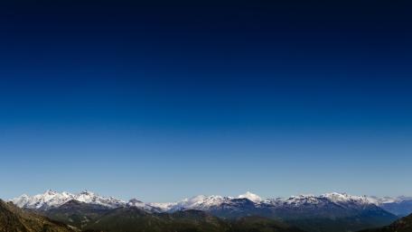 Majestic Snow-Capped Mountains Under Clear Blue Sky wallpaper