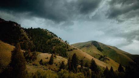 Majestic Mountains Under Dark Clouds wallpaper