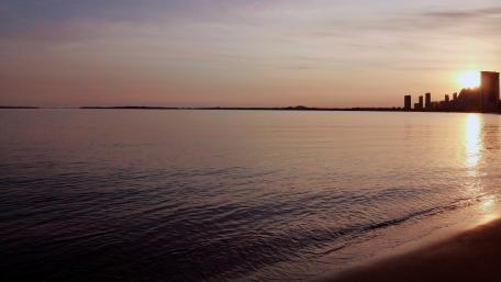 Serene Cityscape at Sunset Over Calm Waters wallpaper