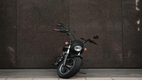 Sleek Black Motorcycle Against Dark Wall wallpaper