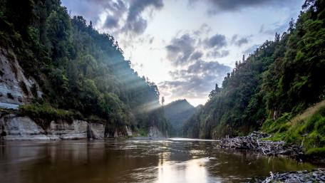 Stream between Mountain and shadows of Sunlight wallpaper