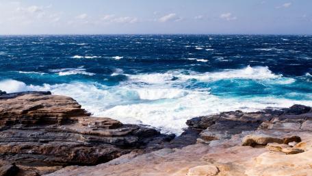 Majestic Waves Against Rocky Shores wallpaper