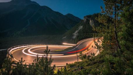 Curving Road Through Nighttime Wilderness wallpaper