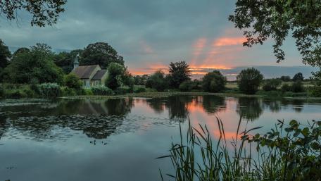 Tranquil Sunset Reflection over Serene Waterway wallpaper