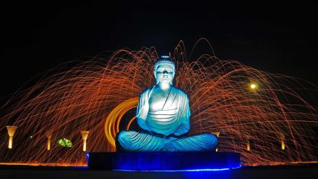 Serene Buddha Statue Amidst Vibrant Fireworks Display wallpaper