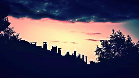 Silhouetted Rooftops Against a Vibrant Sunset Sky wallpaper