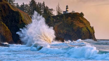 Lighthouse on a Rugged Coastal Cliffside wallpaper