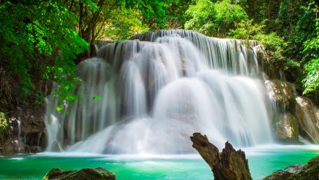 Majestic Waterfall in Serene Forest Setting wallpaper