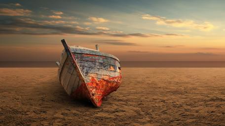 Serene Beachscape with Rustic Boat and Sunset Glow wallpaper