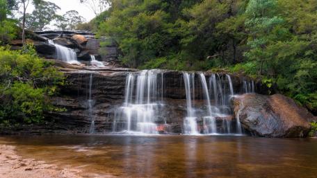 Tranquil Waterfall in Serene Nature Scene wallpaper