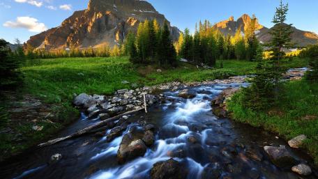 Serene River Flowing Through Majestic Mountains wallpaper