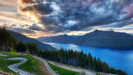 Serene Lakeside View Amidst Majestic Mountains and Vibrant Skies wallpaper