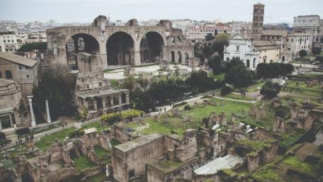Ancient Ruins Overlooking a Modern Cityscape wallpaper