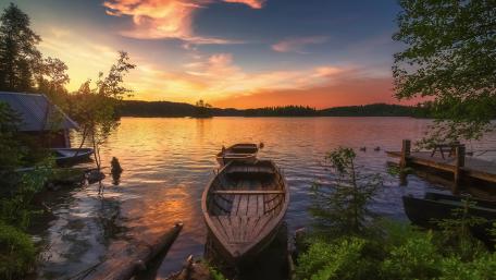 Serene Sunset Over Tranquil Lake Boat Scene wallpaper