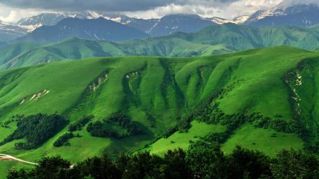 Lush Green Hills under a Dramatic Sky wallpaper