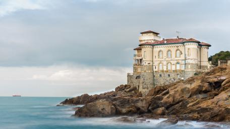 Majestic Coastal Castle Amidst Waves wallpaper