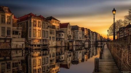 Serene Cityscape at Sunset Over Waterway wallpaper