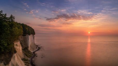 Serene Cliffs at Sunset Over Calm Waters wallpaper