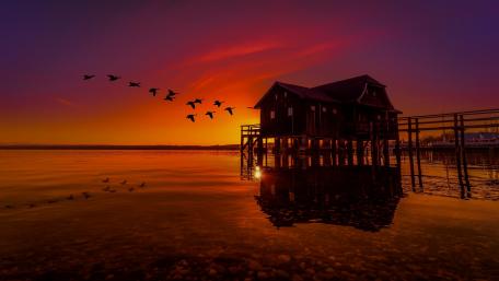 Serene Sunset Over a Tranquil Boathouse wallpaper