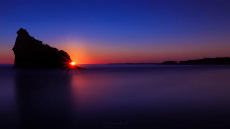 Majestic Purple Sunset Over Tranquil Waters wallpaper