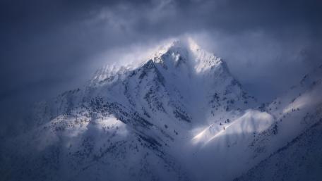 Majestic Snow-Capped Peaks Amidst Mystic Clouds wallpaper