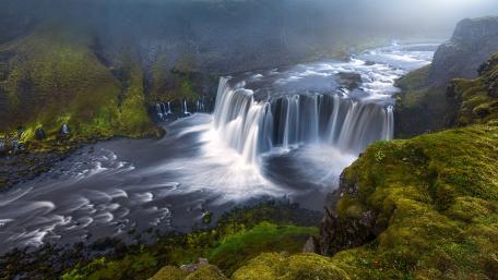 Majestic Waterfall Amidst Lush Greenery wallpaper