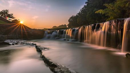 Tranquil Sunrise over a Majestic Waterfall wallpaper