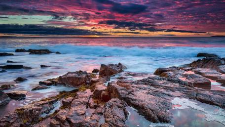 Serene Coastal Sunset Reflections on Rocks wallpaper