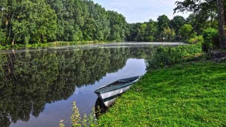 Serene Boat Reflection in Nature's Embrace wallpaper