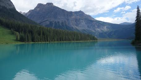 Serene Lake Surrounded by Majestic Mountains and Forests wallpaper