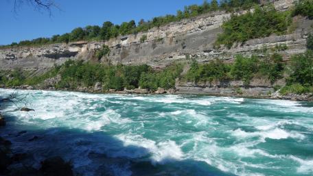 Majestic River Flowing Through Rocky Cliffs wallpaper