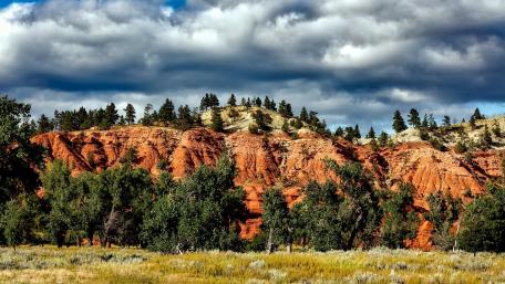 Vibrant Red Cliffs Under Dramatic Sky wallpaper
