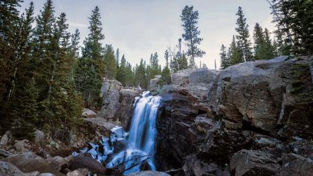 Majestic Waterfall in a Verdant Forest Scene wallpaper