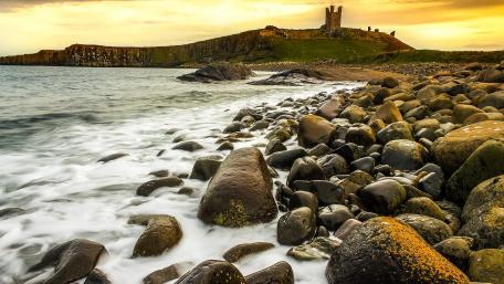 Serene Coastal Sunset Over Rocky Shoreline wallpaper