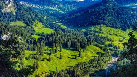 Serene Mountain Landscape with Lush Greenery and Shadows wallpaper