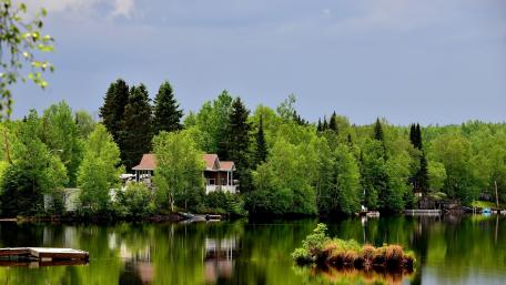 Serene Lakehouse Retreat Amidst Lush Greenery wallpaper