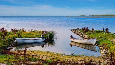 Serene Lake with Boats Amidst Nature’s Beauty wallpaper