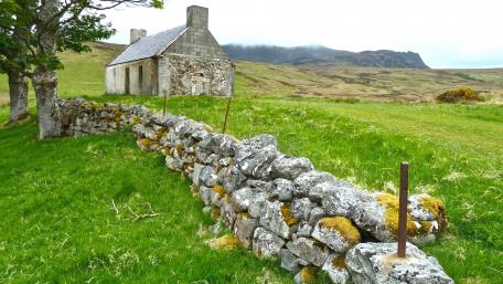 Tranquil Cottage Amidst Lush Green Fields wallpaper
