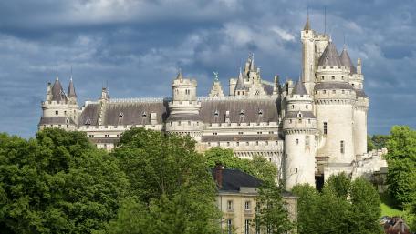 Majestic Castle Surrounded by Lush Greenery wallpaper