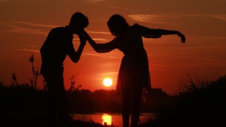Romantic Sunset Embrace with Silhouetted Couple wallpaper