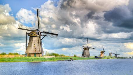 Serene Landscape with Majestic Windmills Over Water wallpaper