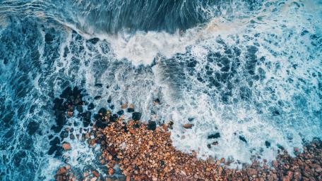 Majestic Waves Churning Above Rocks wallpaper
