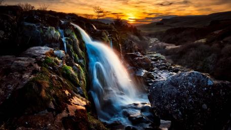Golden Sunset Over Serene Waterfall Landscape wallpaper